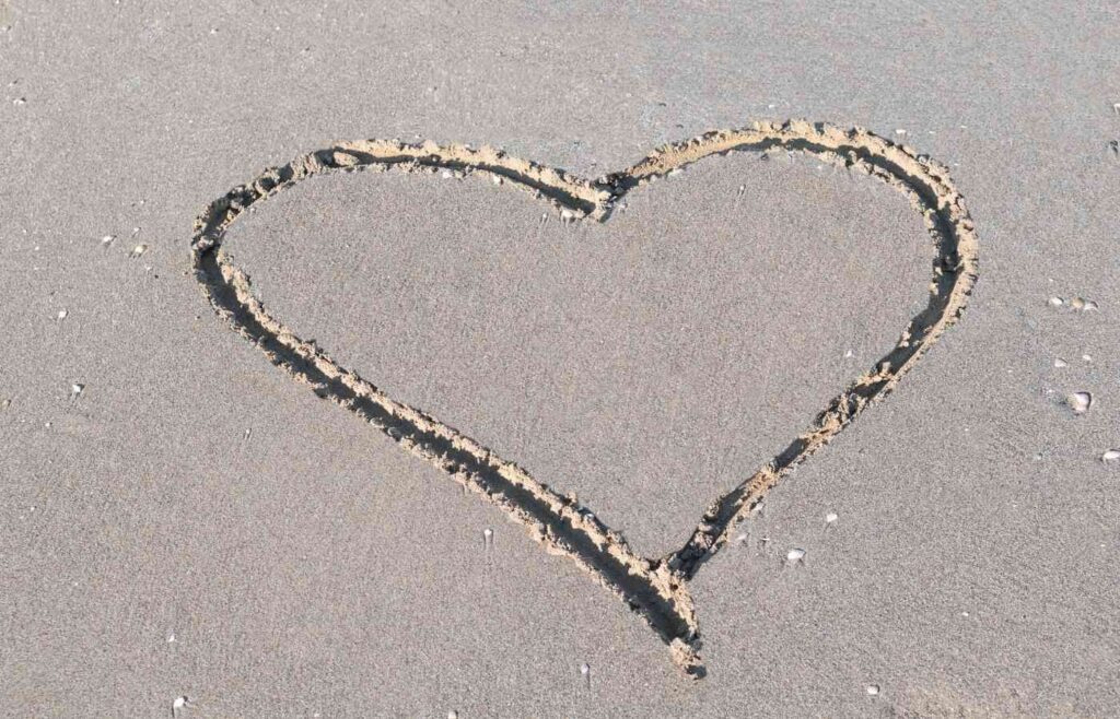 Heart traced in sand.