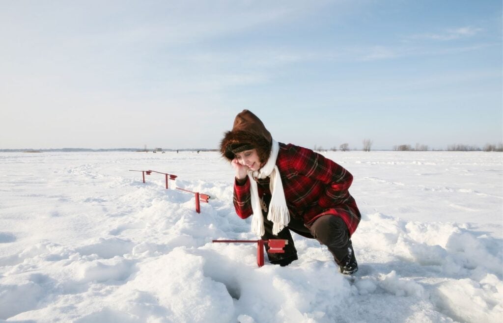 Woman ice fishing in winter.