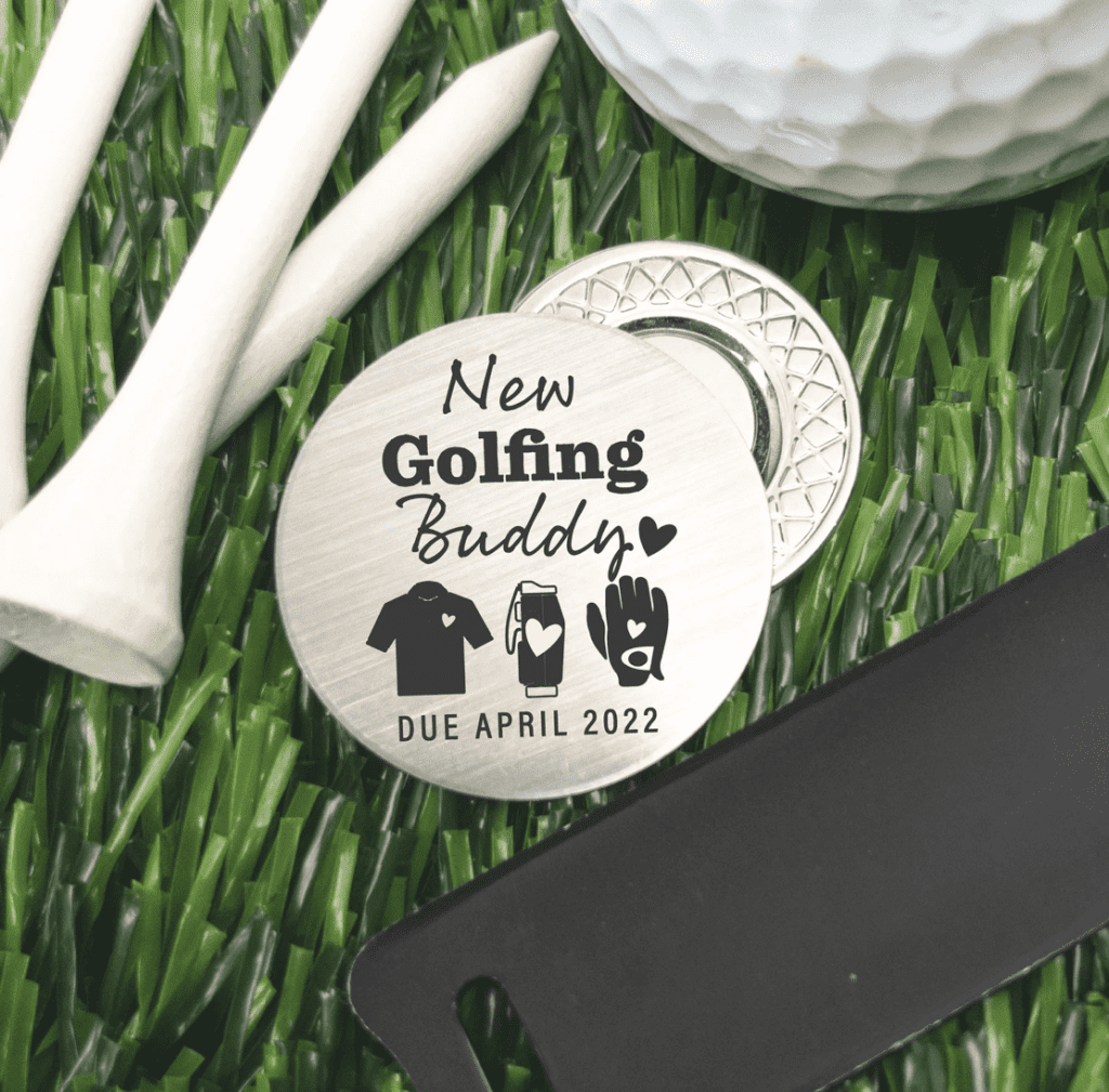 Golf ball marker that says New golfing buddy due in april for pregnancy announcement