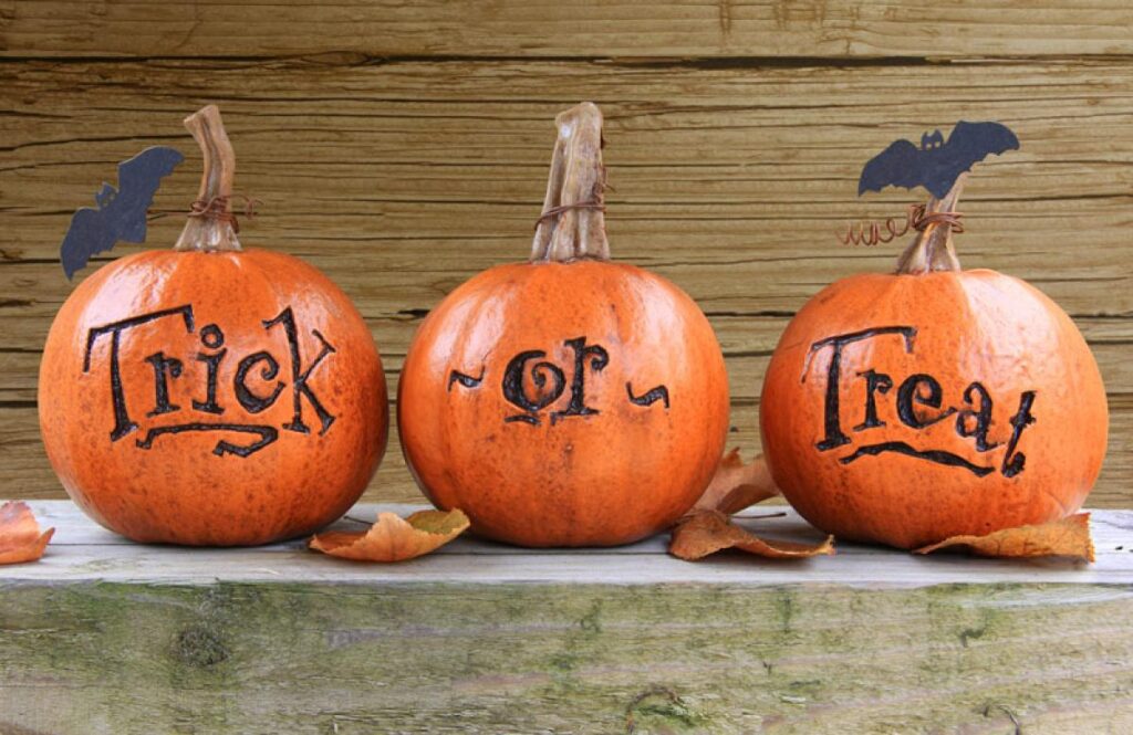 Three pumpkins that say Trick Or Treat with bats on them