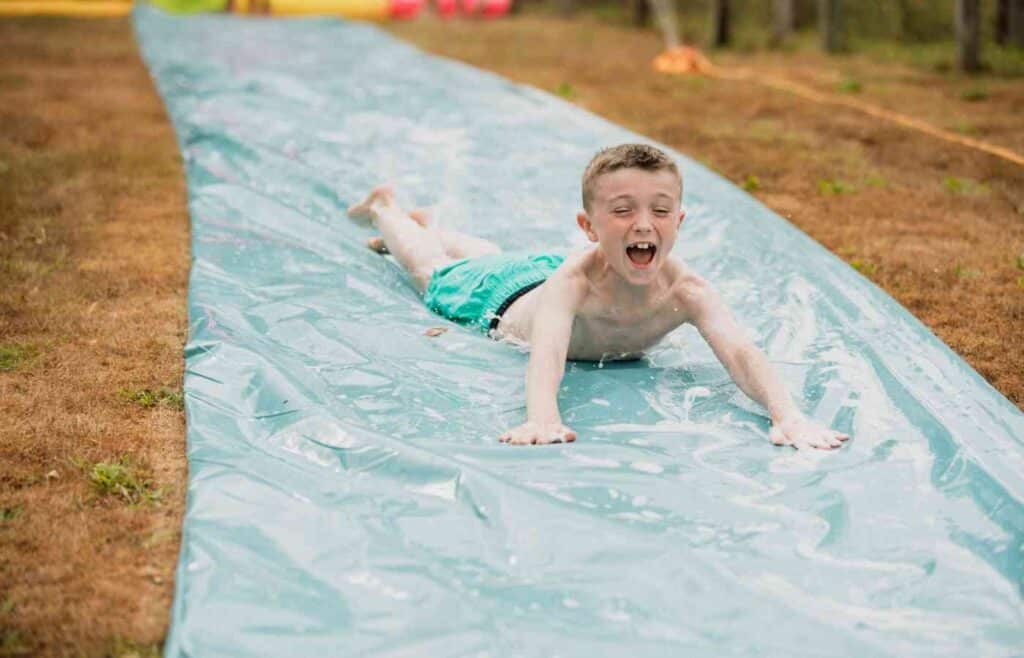 Child boy going down a slip n slide