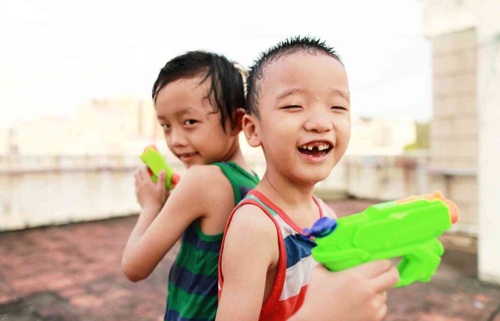 Two kids playing with squirt guns