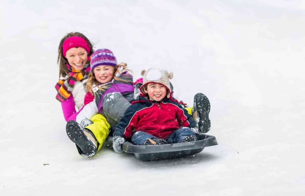 Kids sledding down a hill at a birthday party