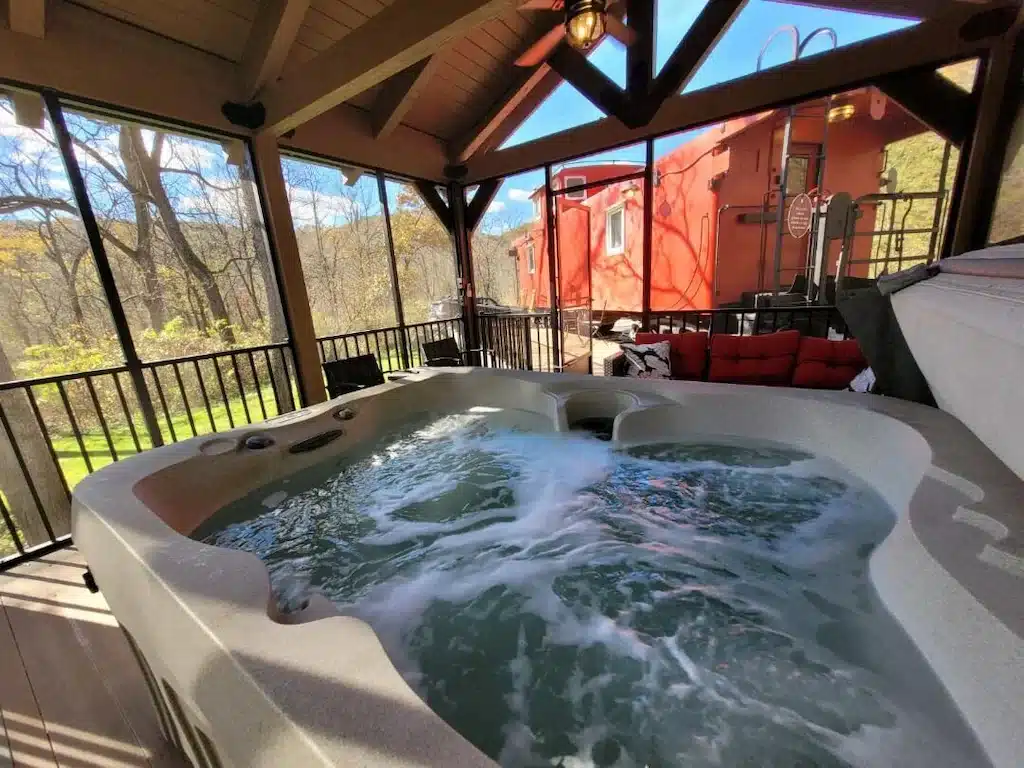 Jacuzzi whirlpool next to red caboose style airbnb.