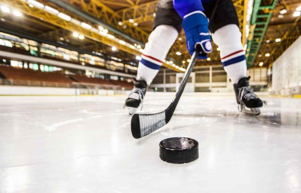 hockey player hitting puck