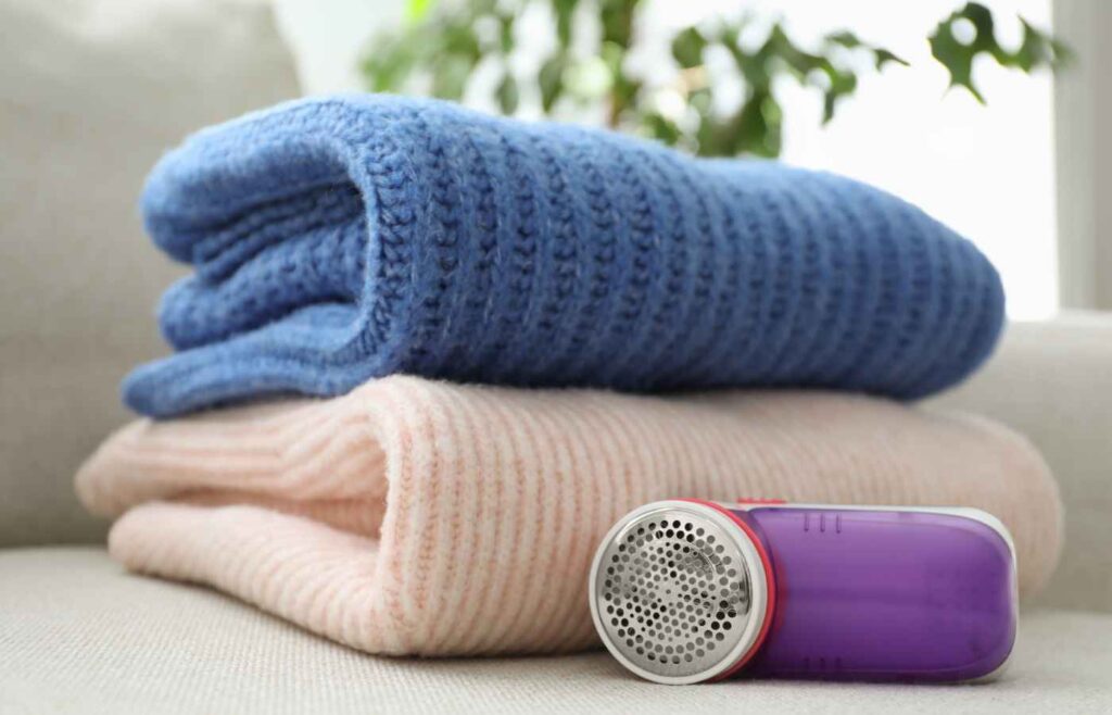 Fabric shaver next to two folded blankets