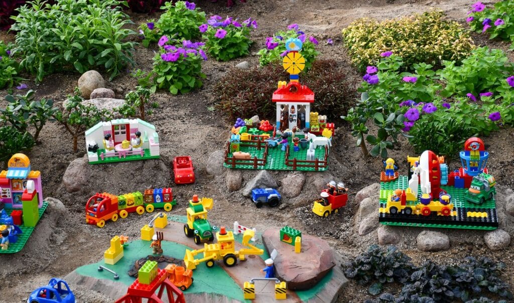 A train lego city built by flowers and other greenery