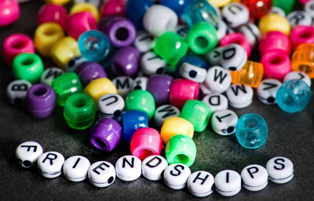 Colorful beads and letter beads spelling 'friendships' for a Swiftie-themed birthday party with friendship bracelets".
