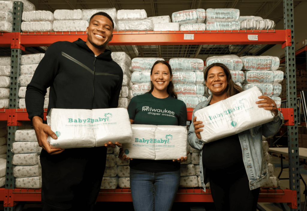 Giannis and Mariah Antetokounmpo help make diapers with Milwaukee Diaper Mission founder Meagan Johnson.