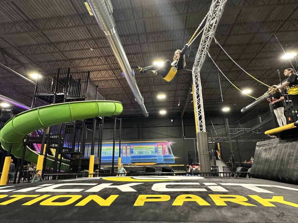 Action shot of a child swinging over a padded landing area at Slick City Action Park in Wauwatosa.