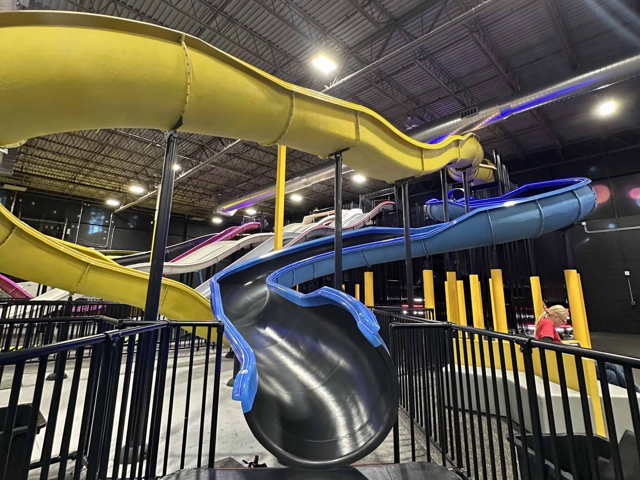 Close-up of interconnected yellow and blue tube slides at Slick City Action Park, showcasing their winding design.