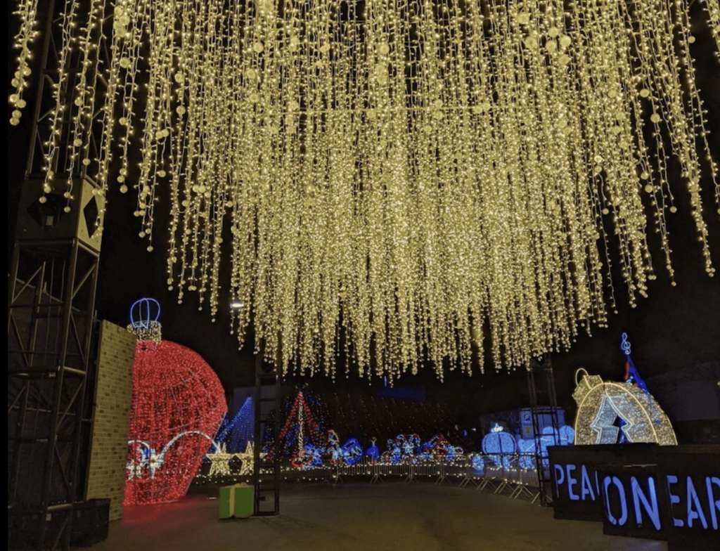 Festive light displays and illuminated sculptures at Kapco’s Kids2Kids Christmas Wonderland, featuring a canopy of hanging lights and giant ornaments in Grafton, Wisconsin.