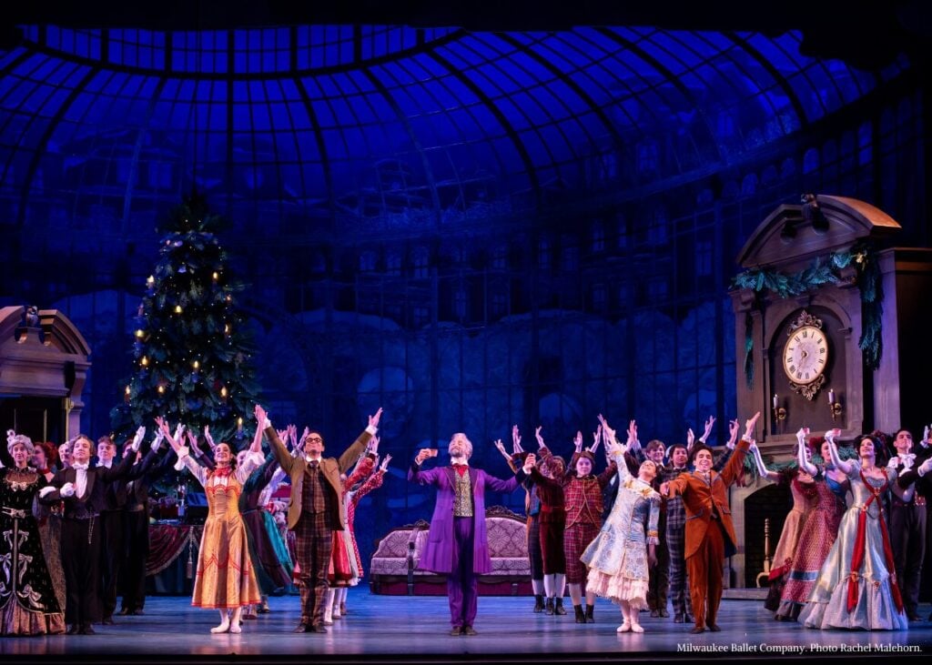 A grand scene from The Nutcracker with performers on stage under a large, illuminated dome, celebrating the holiday spirit.