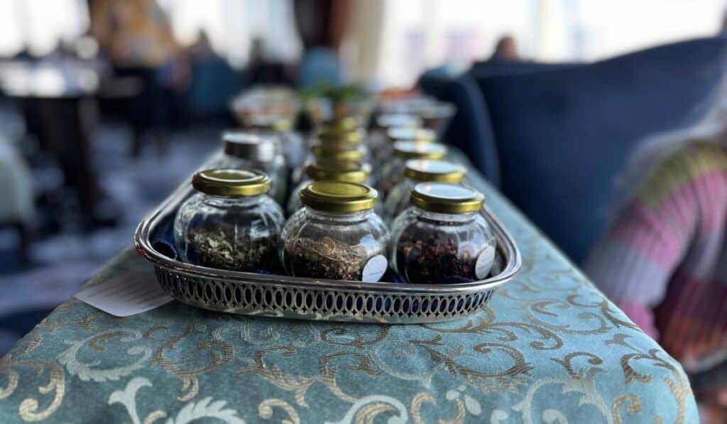 A variety of loose-leaf tea options in glass jars on a decorative table, part of the afternoon tea selection at The Pfister Hotel.