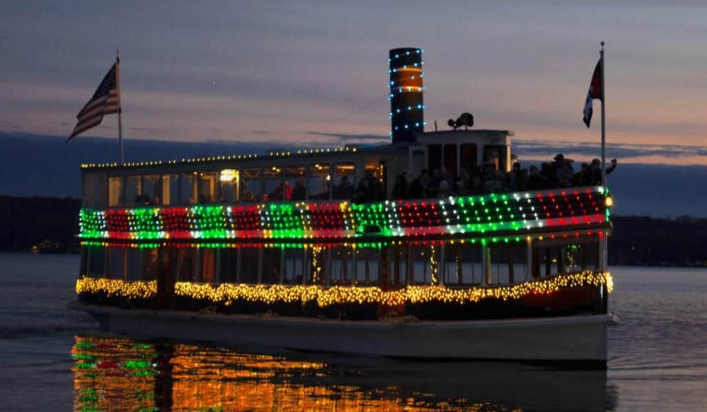 Brightly lit Santa Claus display by the lakeshore in Lake Geneva, with the words 'And to all a Good Night' in festive lights.