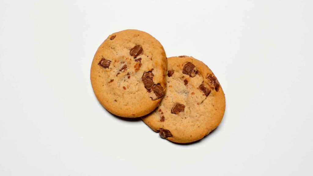 Two chocolate chip cookies on a white background