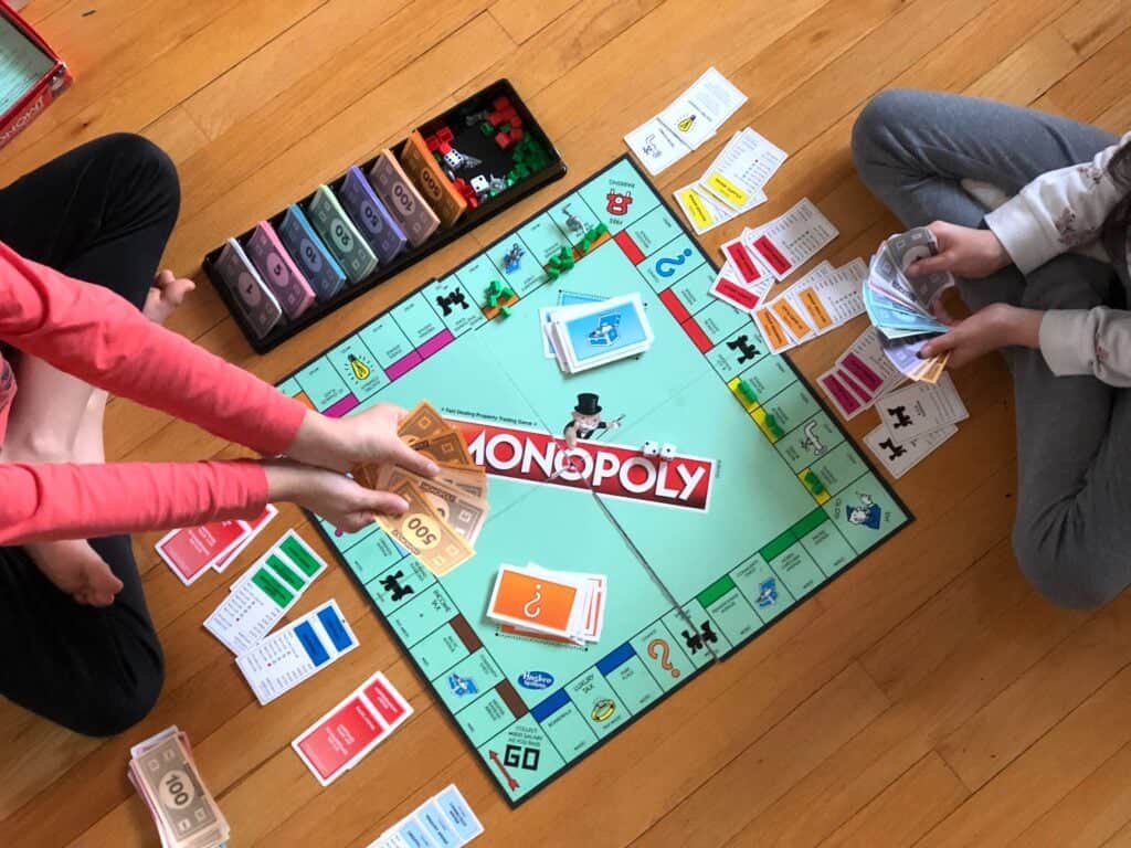 Two people playing a classic Monopoly board game, perfect for a fun board game birthday party for tweens