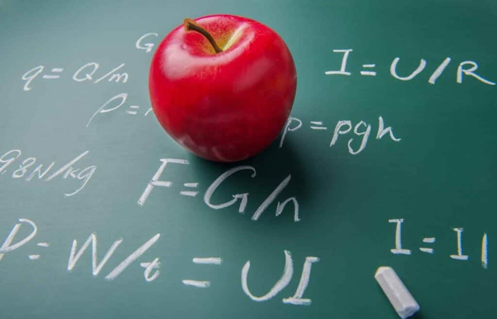 Red apple on a chalkboard with physics equations written in chalk, symbolizing physics concepts in science trivia.