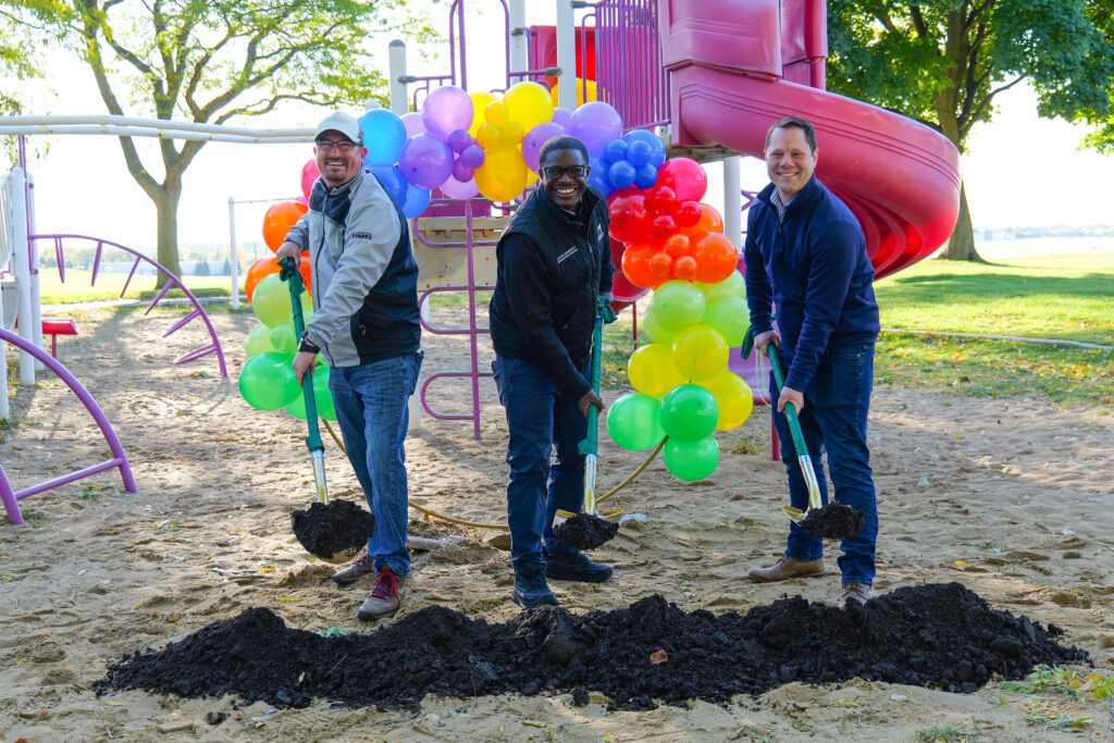 Community leaders and park officials gather to break ground for the new playground at Mitchell Airport Park, surrounded by colorful balloons and the existing play structures. This exciting event marks the beginning of a project that will bring a modern, inclusive playground for children of all ages and abilities, set to be completed by spring 2025.